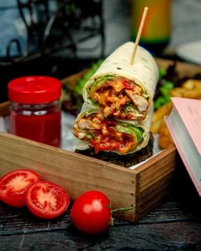 Chicken wraps in flatbread dipped into ketchup Stock Photos