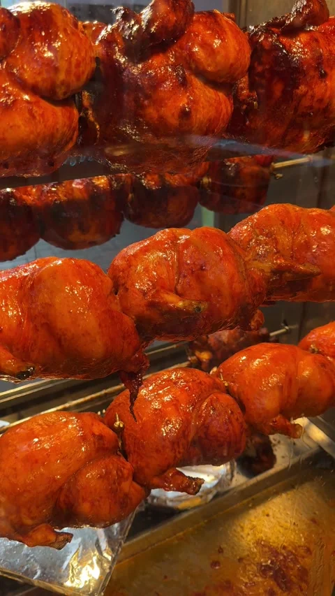 Chickens roasting on a rotating grill, four in a row, visible through the ove Stock Footage 301861013