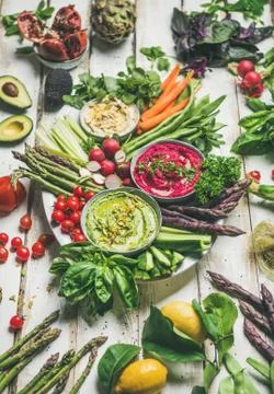 Chickpea, beetroot, spinach hummus dips with fresh vegetables and greens Stock Photos