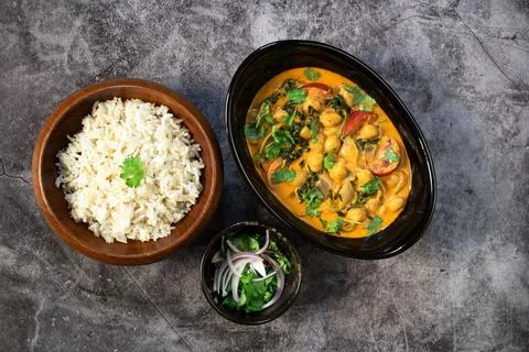 Chickpea curry with spinach has brown rice on black stale table healthy veg.. Stock Photos