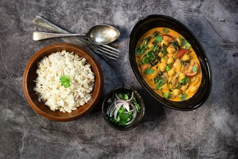 Chickpea curry with spinach has brown rice on black stale table healthy veg.. Stock Photos