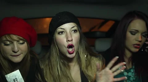 Chicks talking, laughing and making a selfie in the back of a cab Stockbeeldmateriaal 60183937