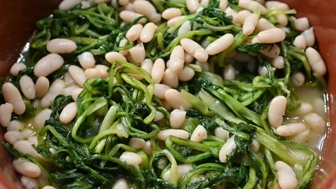 Chicory and bean soup cooked in a terracotta pan (1) Stock Footage 292414537