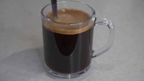 Chicory being stir with spoon in transparent mug Stock Footage 104492749