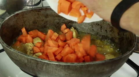 Chief adding sliced carrot and mixing with meat in simmering oil 스톡 동영상 32595952