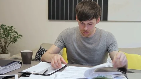 Chief architect examines estimate documentation sitting in office indoors. Stock Footage 77520012