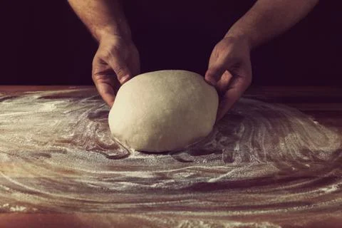 Chief baker preparing dough for bread in a bakery. Kitchen professional. Stock Photos