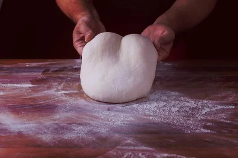 Chief baker preparing dough for bread in a bakery. Kitchen professional. Stock Photos