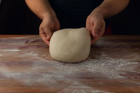 Chief baker preparing dough for bread in a bakery. Kitchen professional. Stock Photos