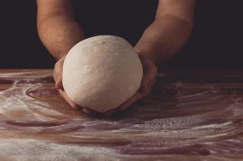 Chief baker preparing dough for bread in a bakery. Kitchen professional. Stock Photos