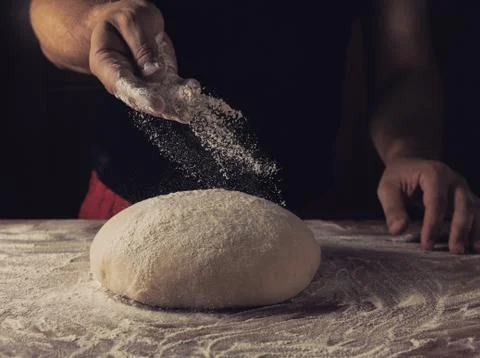 Chief baker preparing dough for bread in a bakery. Kitchen professional. Stock Photos