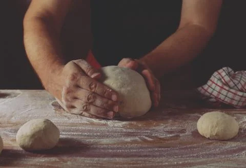 Chief baker preparing dough for bread in a bakery. Kitchen professional. Stock Photos