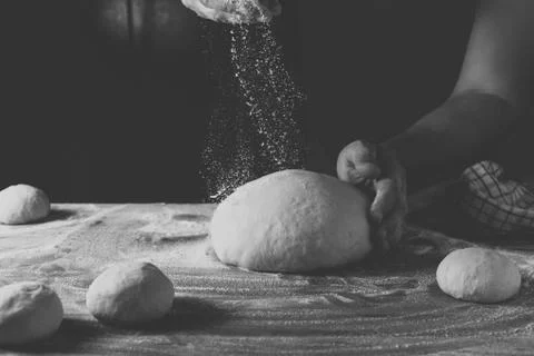 Chief baker preparing dough for bread in a bakery. Kitchen professional. Stock Photos