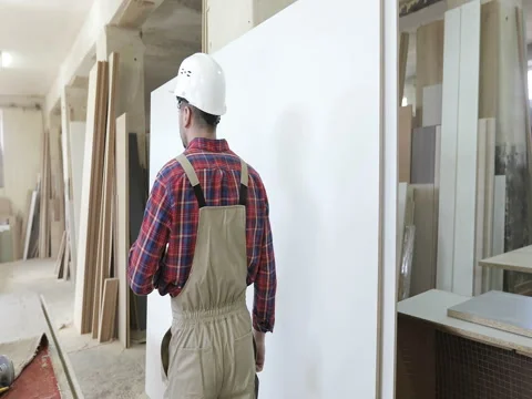 The chief carpenter in the joinery uniform and a white helmet answers the phone Stock Footage 74898682