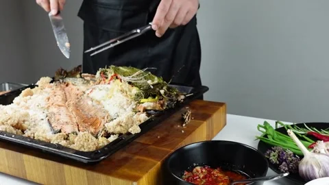 Chief cook is breaking salt and carving fish baked in salt crust. Stock Footage 147940930