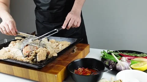 Chief cook is breaking salt and carving fish baked in salt crust. Stock Footage 147940934