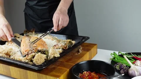 Chief cook is breaking salt and carving fish baked in salt crust. Stock Footage 147940951