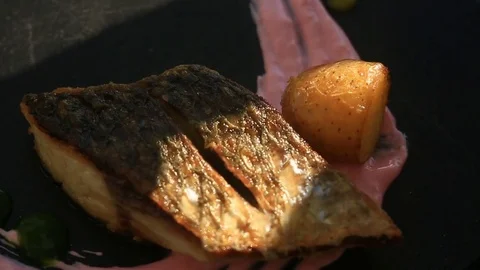 The chief cook decorates a dish of high cuisine with the help of tongs. close-up Stock Footage 77135736