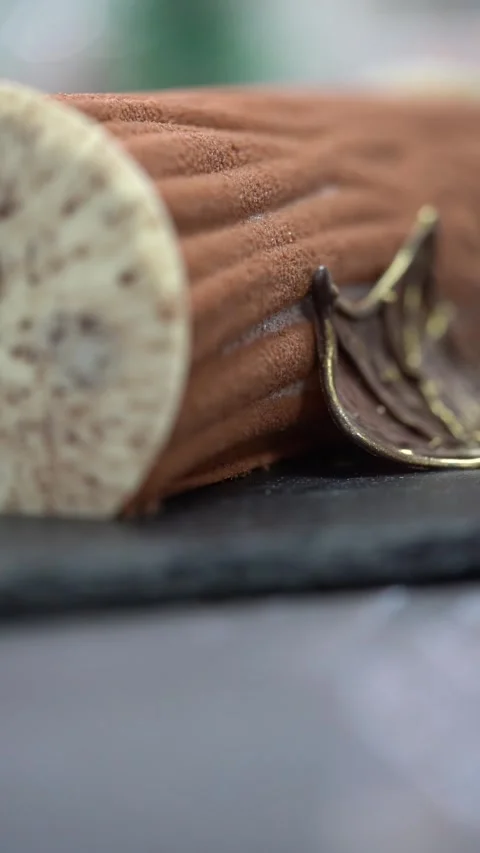 A chief decorates a Chocolate log cake with cherry, textured cocoa coating and Stock Footage 331200461