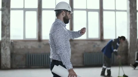 Chief engineer of the construction company goes to a meeting near working people Video stock 130775147