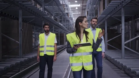 Chief engineer showing two new employees around factory and explaining Stock Footage 108455735