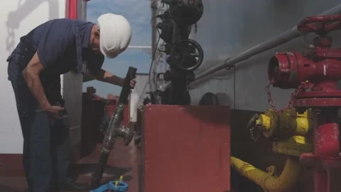 Chief engineer in white helmet checks grey part of pipeline Stock Footage 147171464