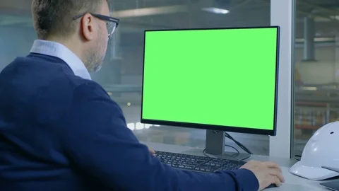 Chief Engineer Works on His Computer with Mock-up Green Screen. Stock Footage