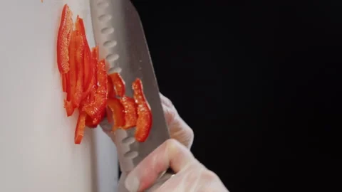 Chief knife cuts the red pepper for small slices. Slicing sweet pepper on white Video stock 169056252