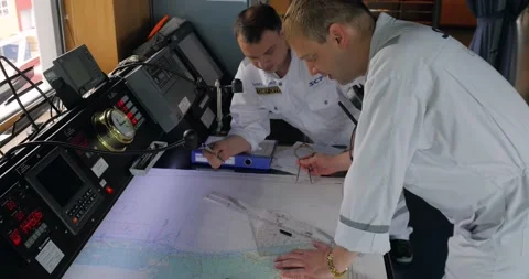 The chief mate and second mate are working with the map on the ship's bridge. Stock Footage 231218752