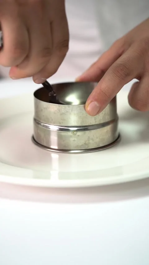 Chief plating a gourmet dish with vegetables and meat in a minimalist style 库存影片 335164675