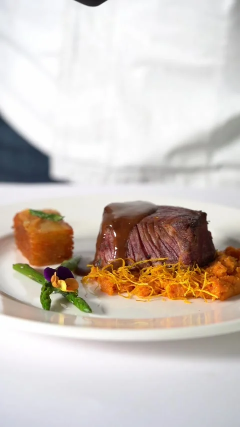 A chief plating Juicy grilled beef steak served on creamy mashed vegetables in Stock Footage 340374030