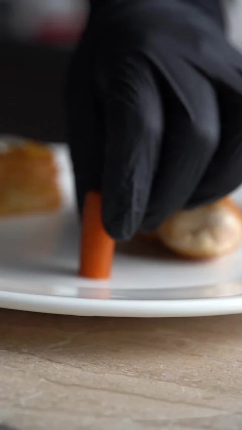 Chief plating roasted chicken piece with carrots and green beans on a plate Stock-Footage 328964998