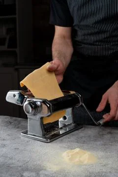 Chief is rolling raw dough in a spaghetti machine to make homemade spaghetti, Stock Photos