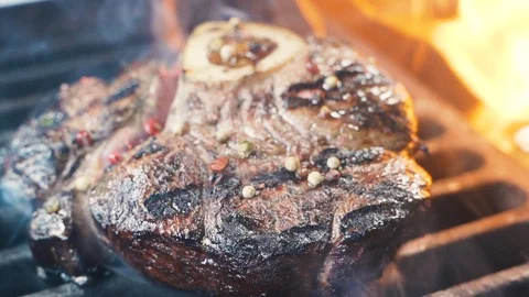 Chief using the spatula and turning the meat on the grill. Stockbeeldmateriaal 107533624