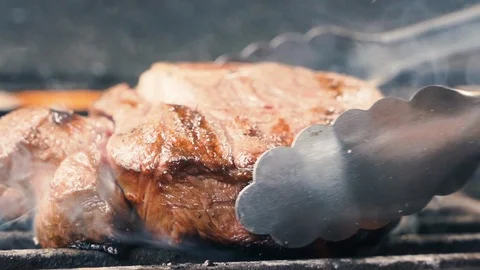 Chief using the spatula and turning the meat on the grill Stock-Footage 107534204