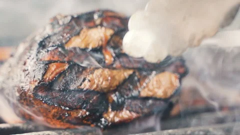 Chief using the spatula and turning the meat on the grill Stockbeeldmateriaal 107534633