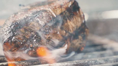 Chief using the spatula and turning the meat on the grill Stockbeeldmateriaal 107534856