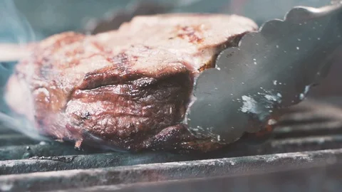 Chief using the spatula and turning the meat on the grill close up Stock-Footage 107537814