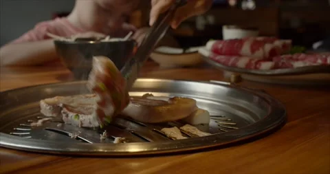Chief using the tong and turning the meat on the grill. Fire is burning, hot Stock-Footage 142324936