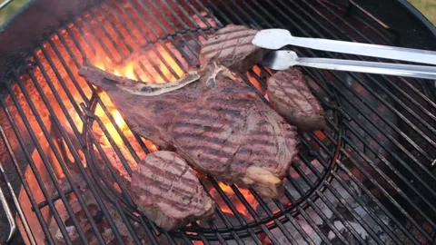 Chief using the tong and turning the meat on the grill. Stock-Footage 148081562
