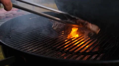 Chief using the tong and turning the meat on the grill. F Stock Footage 148082223