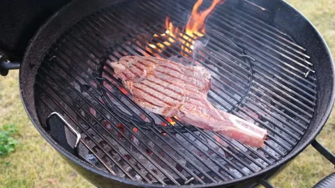 Chief using the tong and turning the meat on the grill. Stock-Footage 148082373