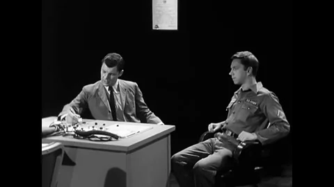A Chief Warrant Officer explains the process as a Polygraph Examiner establishes Stock Footage 79430671