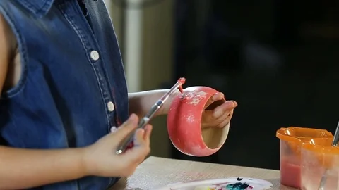 Child, 4-5 year old girl, in the studio. She paints and paints wooden toys. G Stock-Footage 83819004