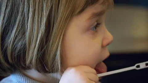 A child 4-5 years old is sitting at the table and picking fork cake. 스톡 동영상 72761900