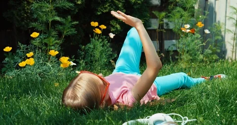 Child 9 aged relaxing lying on the garden at sunny day Video stock 85730888