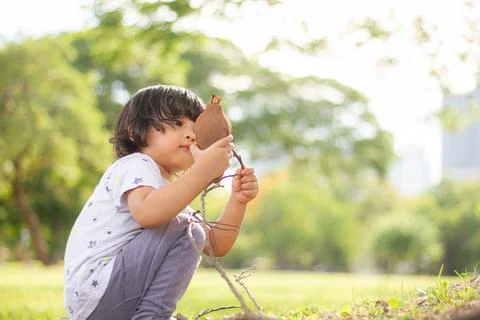 A child of about 3-4 years old wearing a gray star shirt, long pants, red sne Stock Photos
