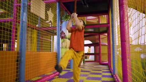The child accelerates and jumps on the hanging rope and rides Stock Footage 169394976
