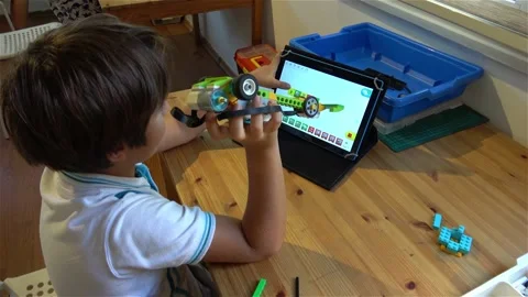 Child activates and tests his robot car at the Robotics lesson Stock Footage 164045222