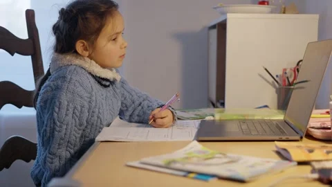 A Child Actively Engaged in Online Learning from the Comfort of Their Home Video stock 303492525